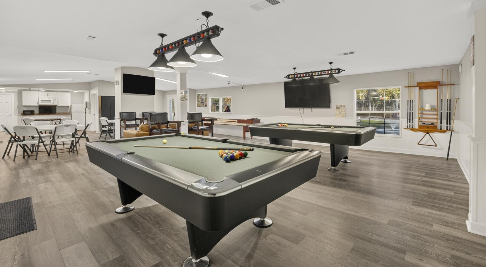a clubroom with pool tables and chairs